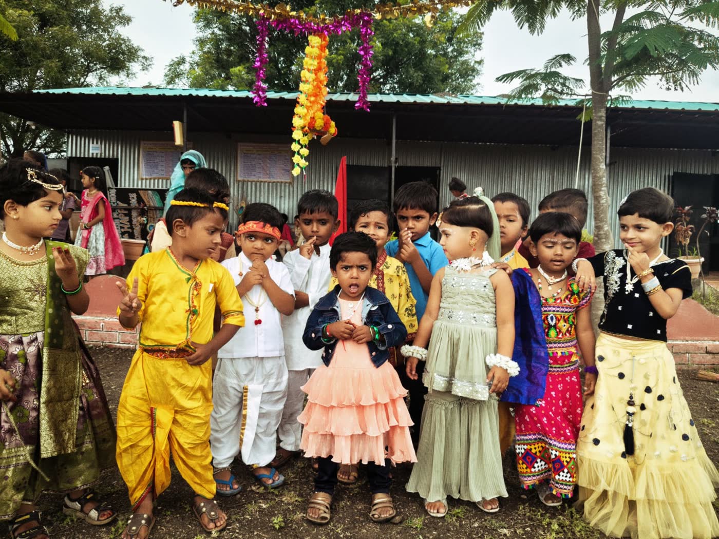 Young children dressed as Radha and Krishna for Janmashtami in front of the classrooms