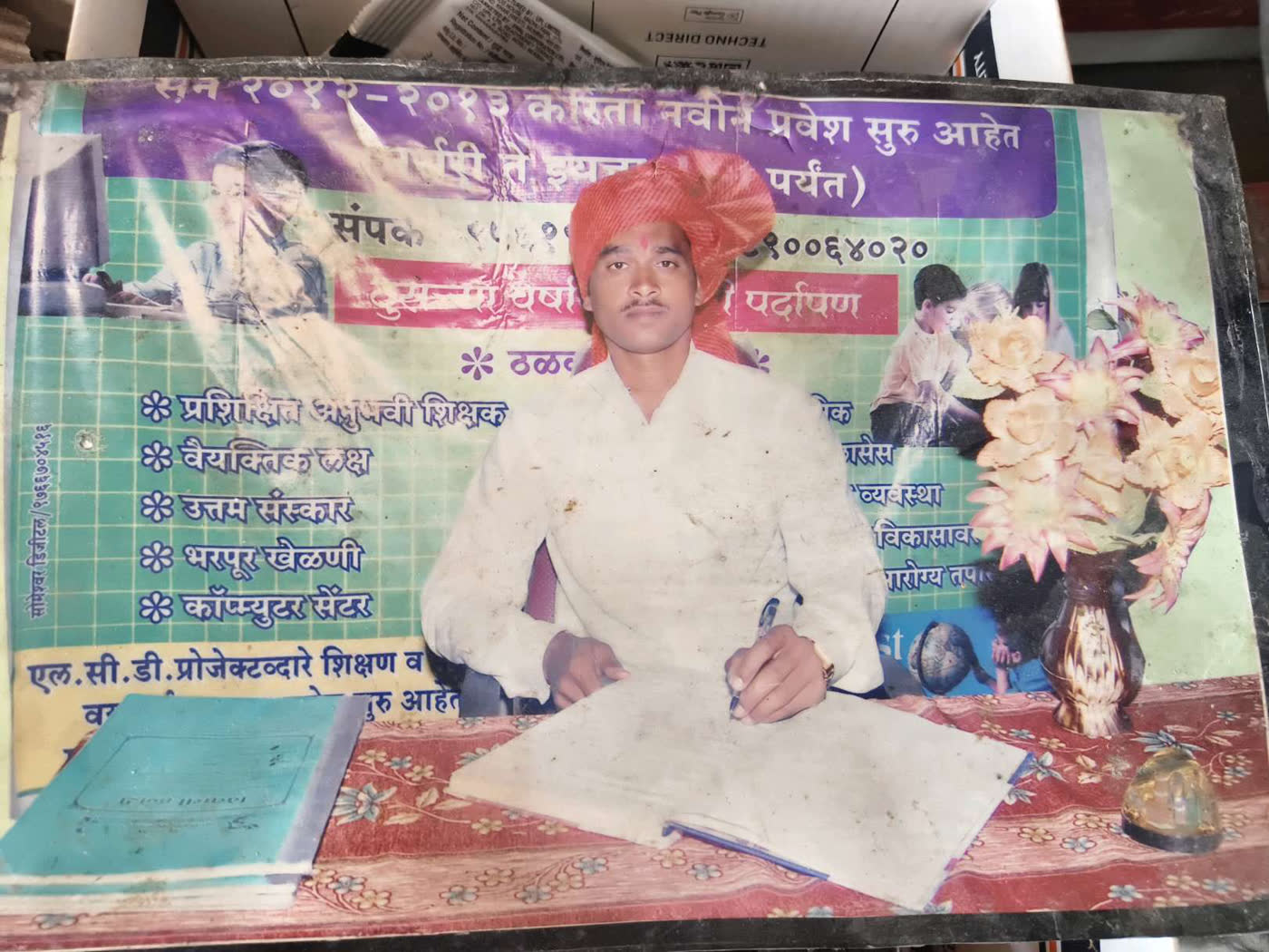 The faded 2012–13 admissions banner, showing Shri Ramjan Shaikh in a saffron pheta seated at a desk, with the school's promises printed on the left